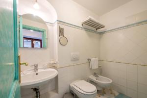 a bathroom with a sink and a toilet and a mirror at Ricciolo d'oro 1 in Positano