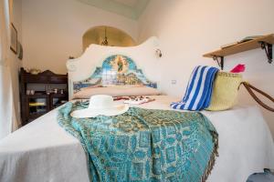 a bedroom with a bed with a hat on it at Ricciolo d'oro 1 in Positano