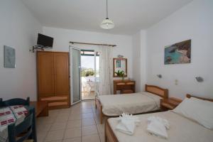 a hotel room with two beds and a balcony at Contaratos Holiday Lettings 3 in Livadi