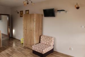 スピシュスケー・ポドフラジエにあるPenzion Chalupka IIの壁に椅子とテレビが備わる客室です。