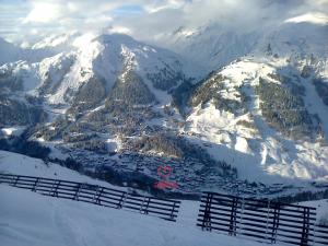 a snow covered mountain with a town in front of it at Alkira in Sankt Anton am Arlberg