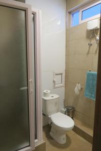 a bathroom with a toilet and a glass shower door at AZ Pereybere Beach Apartment in Pereybere
