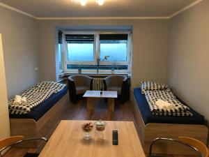 ein Wohnzimmer mit 2 Betten und einem Tisch in der Unterkunft Apartment Maximilians in Düsseldorf