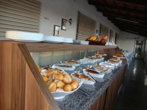 ein Buffet mit Schüsseln voller Brot und Kuchen in der Unterkunft D'arc Hotel in Goiânia