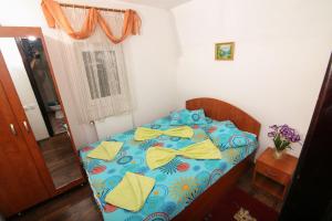 1 dormitorio con 1 cama con edredón azul y amarillo en Vila Cotul Donului, en Timisu de Sus