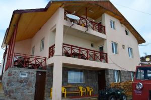 a house with a balcony with yellow chairs at Hotel Toni in Gudauri