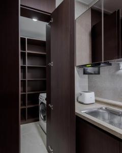 a kitchen with a sink and a washing machine at Elite Apart-Hotel in Astana +12 photos