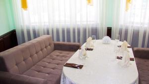 a dining room with a table and a couch at Hotel Ternopol in Zelenodolsk