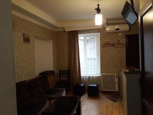 a living room with a couch and a window at Rati apartments in Tbilisi City