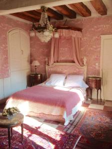 a bedroom with a large bed with pink walls at Manoir de Boisairault in Le Coudray-Macouard