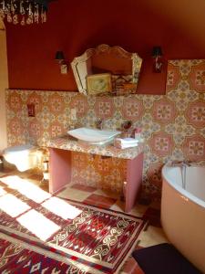 y baño con lavabo, bañera y espejo. en Manoir de Boisairault en Le Coudray-Macouard