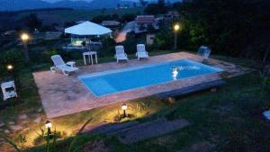 - une vue sur la piscine la nuit dans l'établissement Chácara Stefanini Atibaia com WIFI, à Atibaia