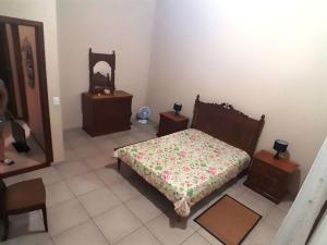 - une chambre avec un lit, deux tables et un miroir dans l'établissement Chácara Stefanini Atibaia com WIFI, à Atibaia