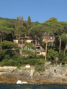 una casa en la cima de una colina con árboles en Villa Tregia en Tellaro