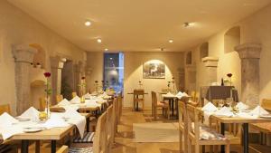 a restaurant with wooden tables and chairs and a television at Naturhotel Gidibauer-Hof in Hauzenberg