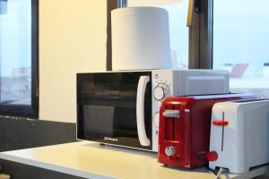 a microwave and a toaster sitting on top of a counter at Oasis Backpackers' Toledo in Toledo
