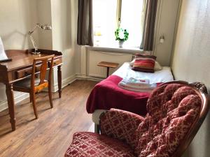Zimmer mit einem Schreibtisch, einem Bett und einem Stuhl in der Unterkunft Järnvägshotellet in Gävle