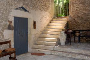 un escalier en pierre avec une porte bleue et un vase dans l'établissement Le Mas des Clots, à Upie