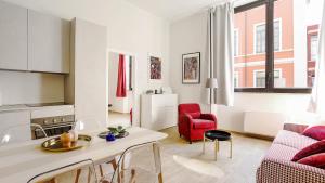 uma sala de estar com uma mesa e uma cadeira vermelha em Italianway-Bergonzoli Place em Milão