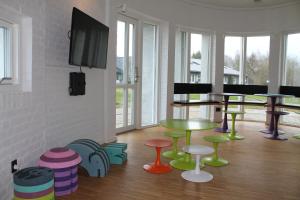 een kamer met kleurrijke tafels en stoelen op de vloer bij Fuglsangcentret Hotel in Fredericia