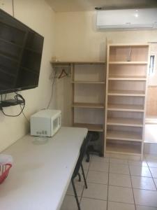 a room with a desk with a computer and a tv at Brisas 54632 in Monterrey