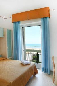 ein Schlafzimmer mit einem Bett und einem großen Fenster in der Unterkunft Hotel Dolores in Rimini