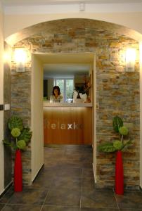 a woman sitting at a counter in a room with a brick wall at Penzion Relaxko in Fulnek