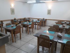 un comedor con mesas y sillas en un restaurante en Hotel Ideal, en Londrina