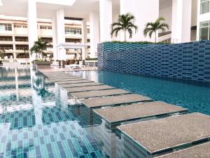 a swimming pool in a building with blue tiles at Pinnacle Tower Apartment Stay by Feel Suites in Johor Bahru