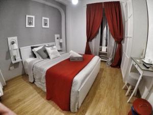 1 dormitorio con 1 cama con manta roja en TuttoTondo Roma, en Roma