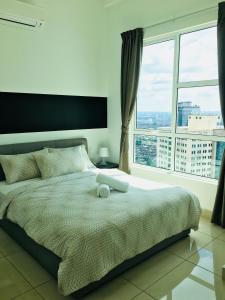 a bedroom with a large bed with a large window at Pinnacle Tower @ Feel Suites in Johor Bahru