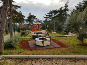 un parque con parque infantil con estructura de juegos en Apartment Dolores Rabac en Rabac
