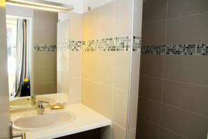 La salle de bains est pourvue d'un lavabo et d'un miroir. dans l'établissement Mermoz, à Marseille