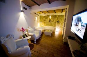 a living room with white furniture and a flat screen tv at Modà Antica Dimora in San Marino