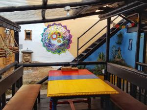a colorful table in front of a wall with a mural at Hostal Bambu in San Agustín