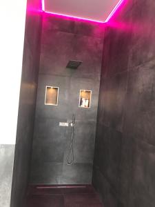 W łazience znajduje się prysznic z fioletowym oświetleniem. w obiekcie Ferienappartement Vastu w mieście Pflach