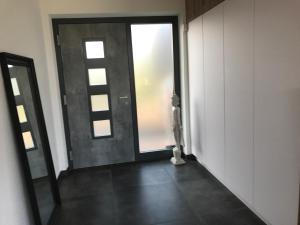 pusty korytarz z drzwiami i oknem w obiekcie Ferienappartement Vastu w mieście Pflach