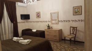 1 dormitorio con cama, silla y vestidor en Sweet Home Cefalù, en Cefalú