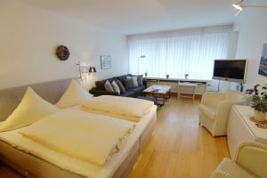 a hotel room with a bed and a living room at Planke 18 in Norderney