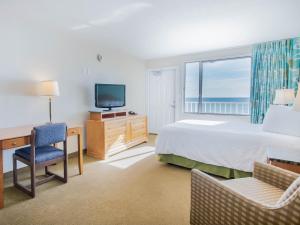a bedroom with a bed and a desk and a television at Beachside Resort Panama City Beach in Panama City Beach