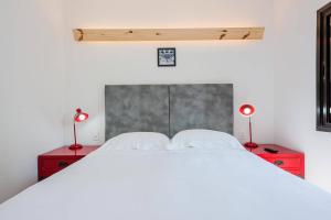 una camera con un letto bianco e due comodini rossi di BHomy Jardins Moderno e descolado MA206 a San Paolo