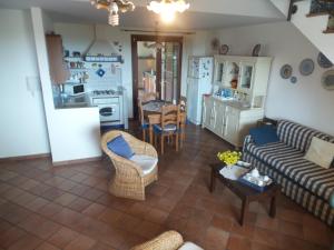 sala de estar con sofá, mesa y cocina en "Villa Rosa", en Marina di Ragusa