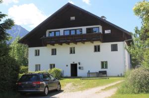 ein Auto, das vor einem weißen Haus parkt in der Unterkunft Ferienwohnung Lech in Pflach