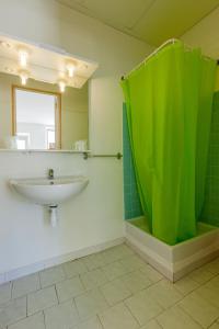 a bathroom with a sink and a green shower at L'Escale Plage in Algajola