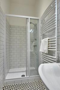 uma casa de banho branca com um chuveiro e uma banheira em Schieszl Apartments 1 em Budapeste