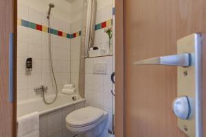 a bathroom with a toilet and a shower at Boardinghouse Mundsburg in Hamburg