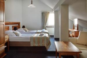 ポズナンにあるRezydencja Solei Old Townのベッド2台とソファが備わるホテルルームです。