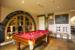 a pool table in a room with a chalkboard at The Woolpack Inn in Brown Candover