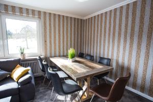 uma sala de jantar com uma mesa de madeira e cadeiras em Landhaus Heinrichs Willingen em Willingen