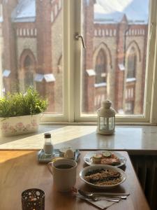 a table with a plate of food and a tea kettle at Järnvägshotellet in Gävle +48 photos